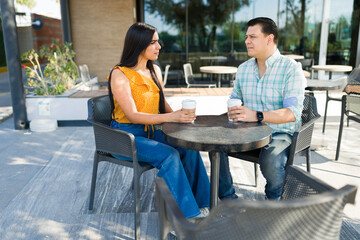 Couple discussing a serious topic while drinking coffee at an outdoor cafe, having a deep conversation about their relationship