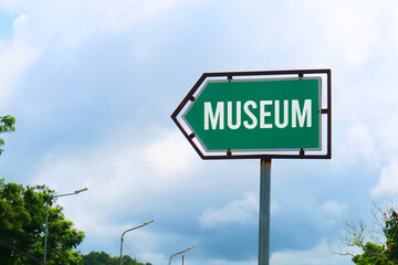 Fototapeta premium Museum Road Sign with Dramatic Clouds and Sky.