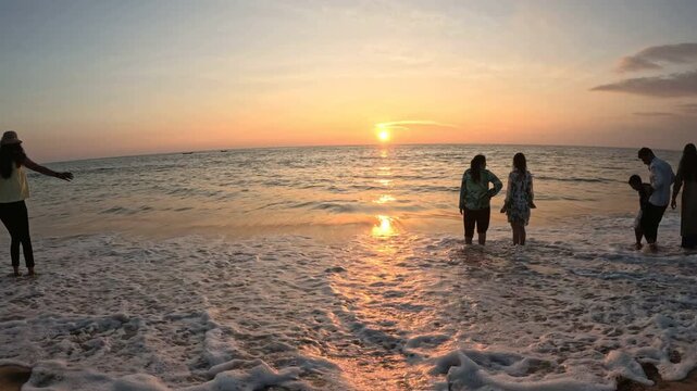 Family enjoying sunset at beach, Arabian Sea