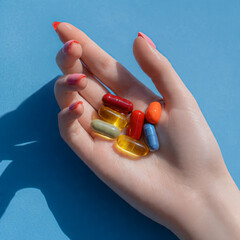 Main de femme tenant des g&eacute;lules