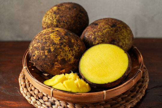 Citrus aurantifolia known locally as limus fruit in Sundanese culture. Traditional Indonesian citrus with thick peel and yellow flesh on rustic wooden background.