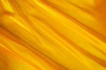 Rich golden silk texture with dynamic folds and luminous sheen for premium abstract design projects.