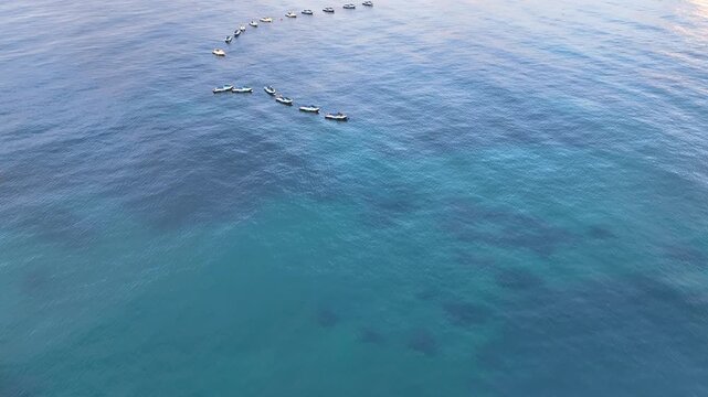 Aerial descends to placid blue sea off Benidorm and nineteen moored jet skis