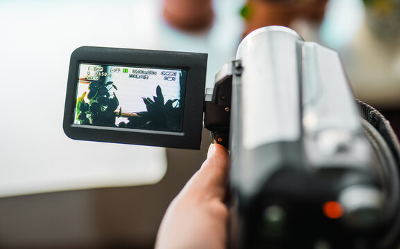 Hand with retro camcoder with LCD flip screen.