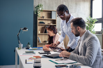 Diverse business team collaborating using digital tablet in office
