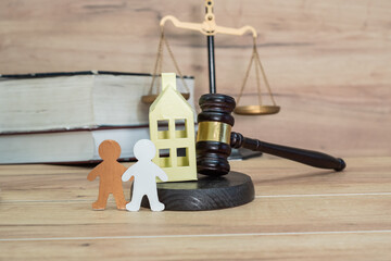 Figurines, a house with a judge's gavel. Legal decision on property rights, housing rights. Real estate laws, legality of home ownership. Illegal occupation of housing. Inheritance, property division