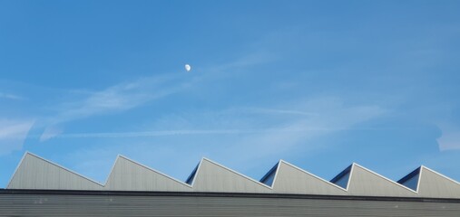 Geometric triangular industrial factory roof under moon. Mobile photography, real phone snapshot