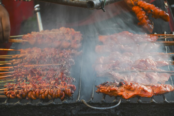Grilled chicken on bamboo skewers served on banana leaves.