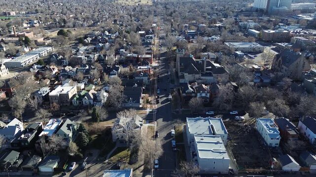 Main road runs north through dense residential grid near Curtis Street, flanked by pitched-roof homes, low-rise buildings. Leafless trees, parked vehicles, define winter layout, Denver, Colorado