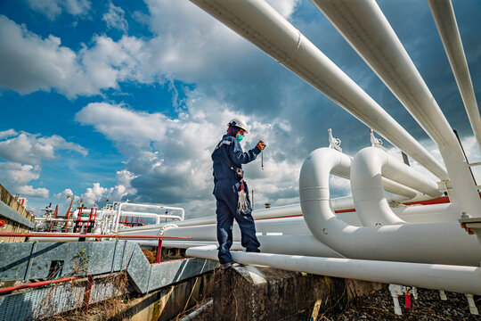 Production operator opening ball valve at pipeline oil and gas wellhead remote platform to control gases