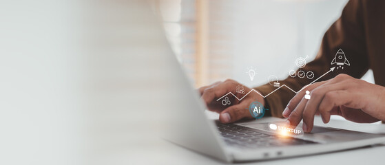 Businessman is focused on a laptop, launching an AI-powered business startup , growth graph, strategy icons, and a rocket, symbolizing innovation, technology, and rapid success.