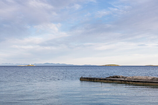Peaceful Seascape With Pier and Distant Islands Under Clear Blue Sky, Orebic, Croatia