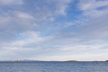 Obraz premium Serene Seascape With Calm Ocean And Distant Islands and Lighthouse Under Clear Blue Sky, Orebic, Croatia