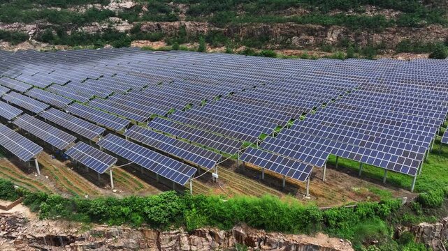 Solar photovoltaic power station neatly arranged on a hillside with rows of panels
