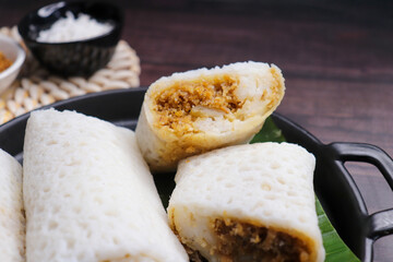 A closeup shot of a traditional Goan Alle Belle coconut pancakes. The crepes are rolled neatly and...