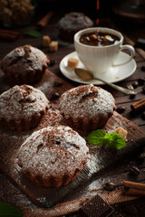 Fototapeta premium Chocolate muffins with powdered sugar and coffee for breakfast