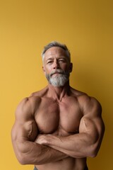 Fototapeta premium muscular mature aged man on yellow studio background