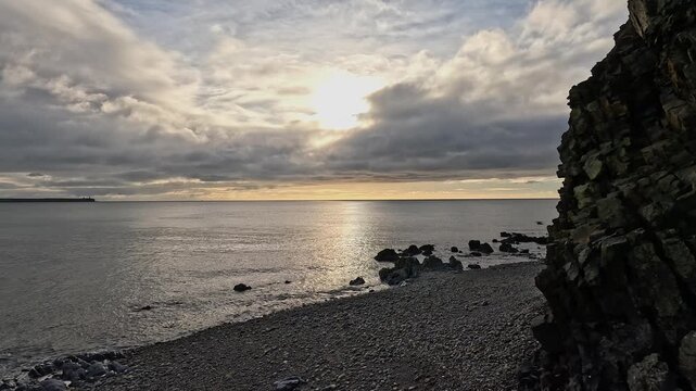Peaceful golden afternoon light on calm ocean seen from sea cliff shore