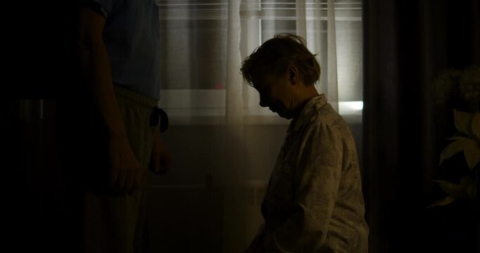 Silhouettes of a man and a woman sorting things out in a room.