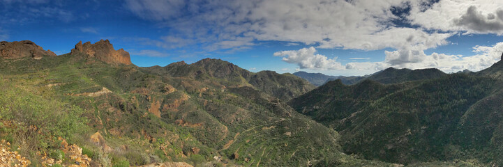 Panoramic view of lush mountain landscape under a beautiful sky
