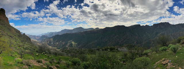 Panoramic view of a mountainous valley under a cloudy sky
