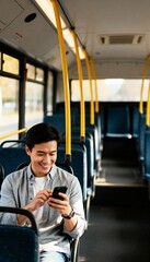 Young man smiling while using smartphone on empty bus