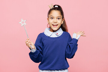 Little kid girl 8-9 years old she wear blue shirt crown diadem have fun hold magic wand fairy stick isolated on pink color background child studio portrait. Mother's Day love family lifestyle concept