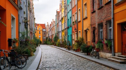 Obraz premium Cobblestone street lined with colorful historic buildings. Vibrant architecture in European city for travel and tourism concept.