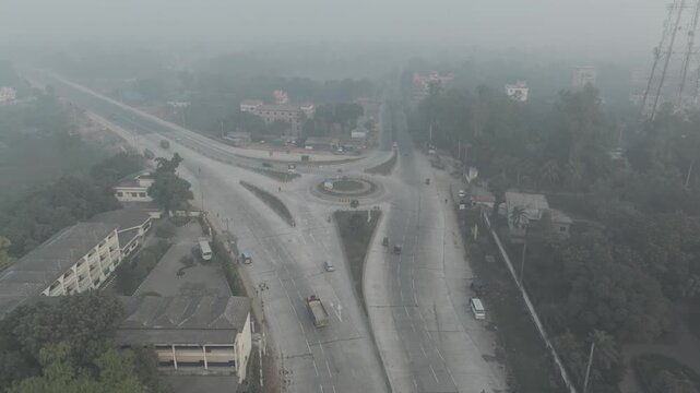 Aerial circular shot of Banani Mor roundabout with traffic during hazy morning in Bogura, Bangladesh