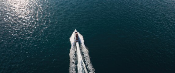 Two speed boats swiftly moving on dark blue water with aerial view