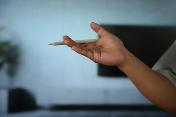 hand gracefully cradling a minimalist stylus. The clean, blurred studio background emphasizes a sleek, modern aesthetic perfect for creative technology and digital artistry.