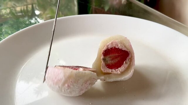Japanese dessert mochi with strawberry filling. Sliced mochi with strawberry filling close-up.