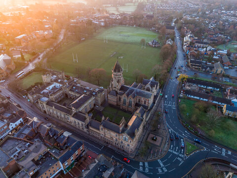 Aerial view of an imposing building with a tower stands proudly amidst the urban landscape, its intricate architecture catching the soft light, Rugby, England, United Kingdom.