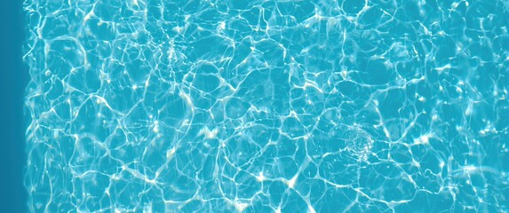 Light blue swimming pool with bright ripple surface and sun reflection, top view through transparent floor, abstract water glare detail for background or wallpaper