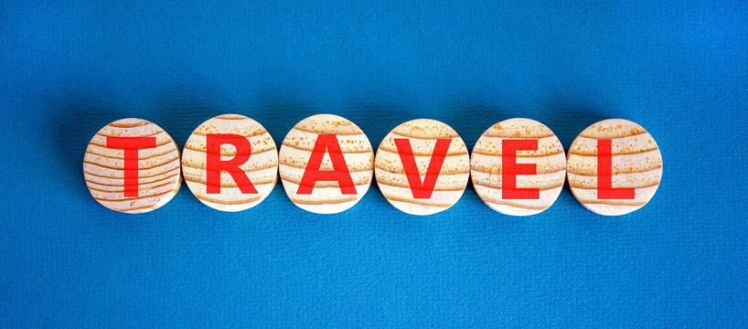 Travel traveling touristic word symbol. Concept word Travel on beautiful wooden circles. Beautiful blue background. Business travel traveling touristic word concept. Copy space.