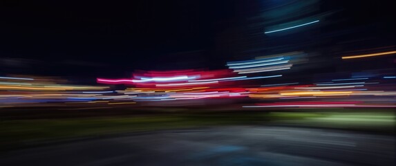 Bright, blurred nighttime background featuring swift light trails
