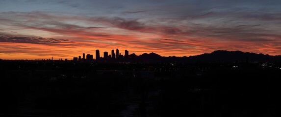 Obraz premium Breathtaking desert cityscape of Phoenix at twilight with dramatic horizon and silhouette