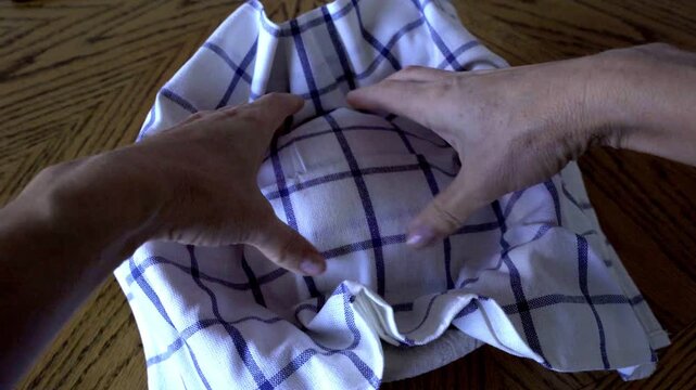 Gently place the dough into a special rising basket, allowing it to proof and grow in volume. Then cover it with a clean towel. Capture the scene from a front‑top angle, showcasing the basket and the 