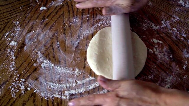 Roll out a small ball of dough. Show it from the side view. Follow traditional recipes. Let&rsquo;s prepare Adjarian khachapuri step by step. You can see feminine Caucasian hands skillfully rolling the doug