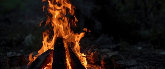 Detailed view of burning firewood with glowing embers and orange flames outdoors