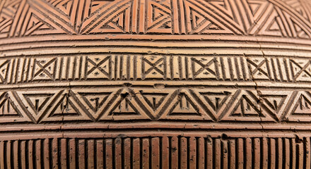Ancient terracotta surface with intricate hand-carved geometric patterns.