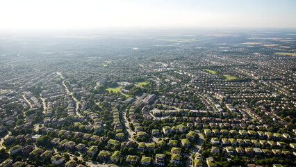 Expansive Aerial View of a Suburban Residential Area and Cityscape Under Hazy Sunlight