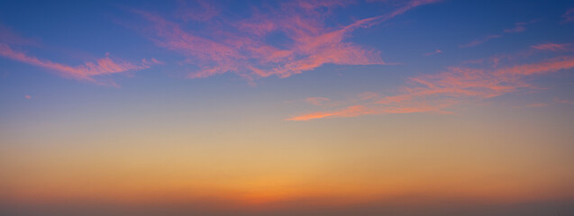 Fototapeta premium Colorful clouds and sky. Dusk and sunset. Evening clouds with orange, yellow, pink and red sunlight and amazing storm clouds in the dusk sky,Dramatic sunset sky with colorful clouds over city,