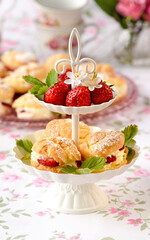 Cream puffs cakes or profiterole filled with whipped cream served with strawberries