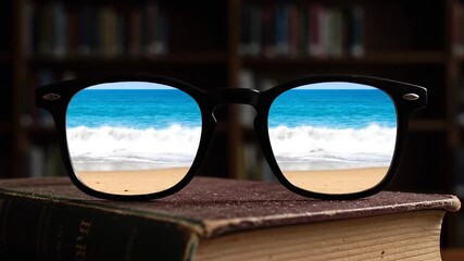 A pair of glasses resting on books in a dark library shows a wave repeatedly crashing onto a sunny beach and receding in its lenses, symbolizing a longing for escape or vacation while studying.