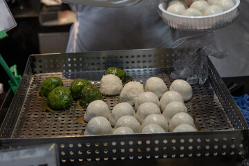Preparing Chinese steamed buns at Asian street food stall, traditional baozi cooking process, travel and local culture concept