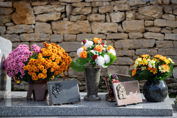 Gros bouquets de fleurs fraiches et multicolore d&eacute;pos&eacute;s sur les tombes dans cimeti&egrave;re &agrave; l'occasion de la Toussaint. France. Cela rend hommage au d&eacute;funt et t&eacute;moigne de l'attachement et du respect.