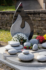 Bouquets de fleurs fraiches et multicolore déposés sur un jardin du souvenir dans cimetière à...