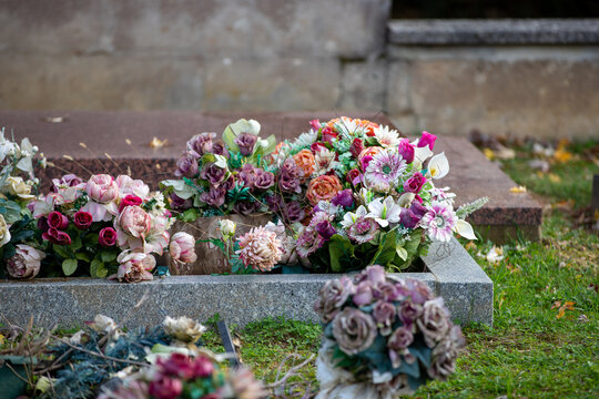 Ancienne tombe dans un cimeti&egrave;re, dans laquelle sont d&eacute;pos&eacute;s et r&eacute;unis les vieux pots de fleurs. Nettoyage avant le d&eacute;p&ocirc;t dans le bac &agrave; d&eacute;chets. France.