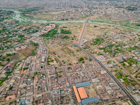 Aerial view of the city's fabric interwoven with the silver thread of the river and the straight line of the bridge, Kaduna, Kaduna, Nigeria.
